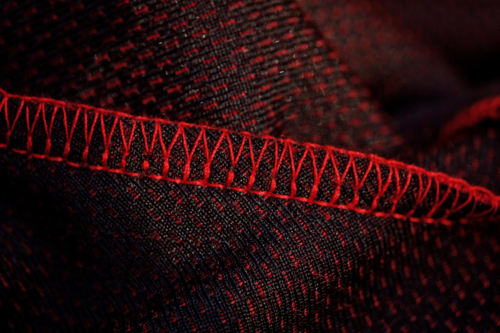Close-up modern embroidery on dark fabric with tech-styled stitches